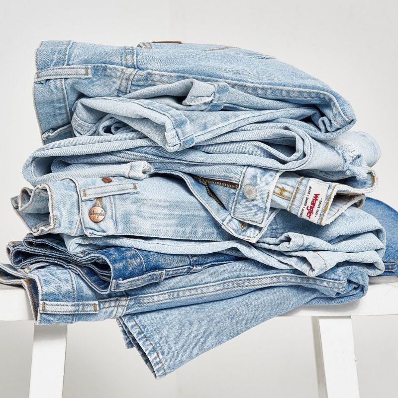 Studio shot of folded jeans stacked on a chair.