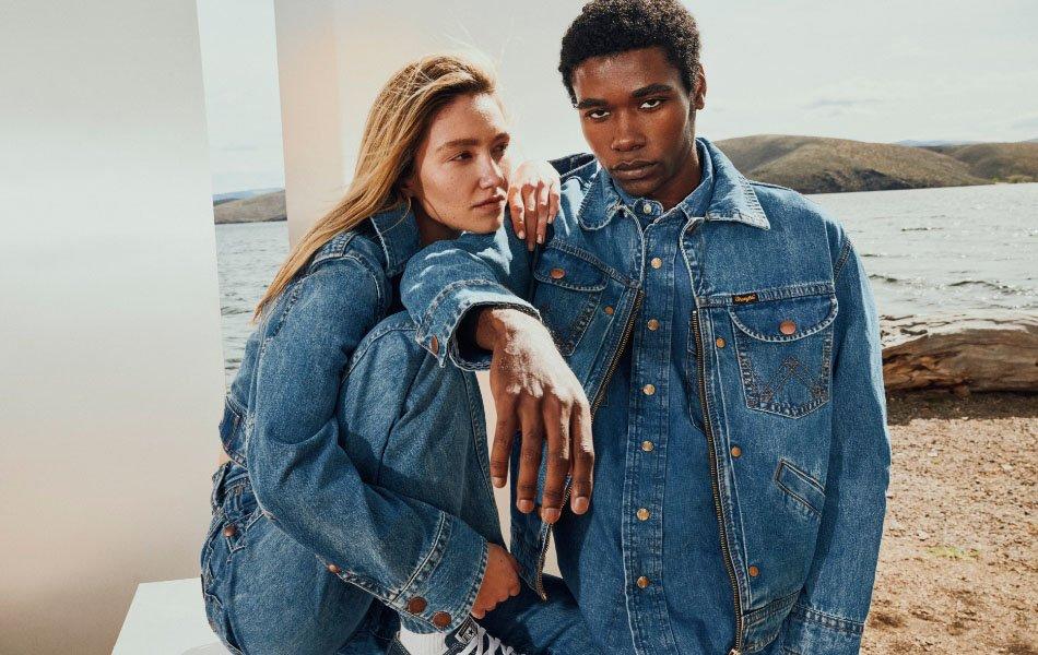 Guy and girl sitting, wearing Wrangler Superjeans