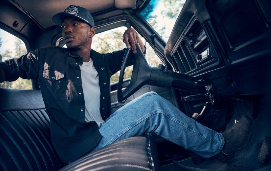 Guy sitting in a vintage truck wearing toughlite jeans