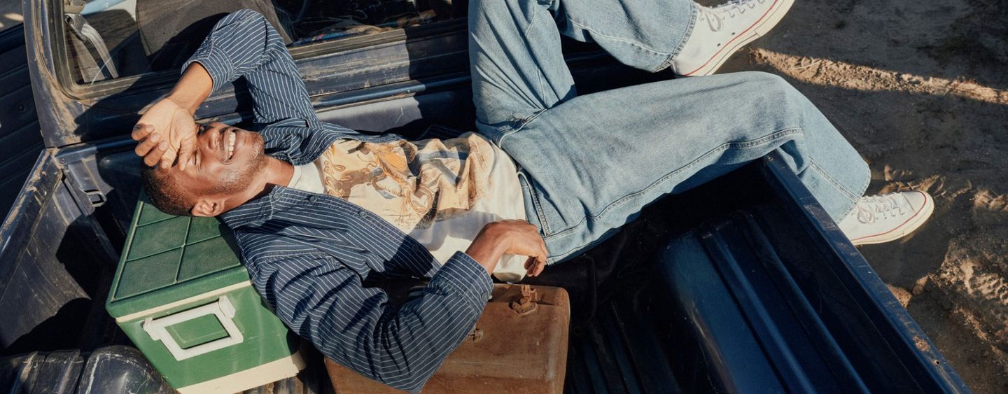 Guys wearing fall clothes, gathered round a vintage truck in the woods. Shop Fall