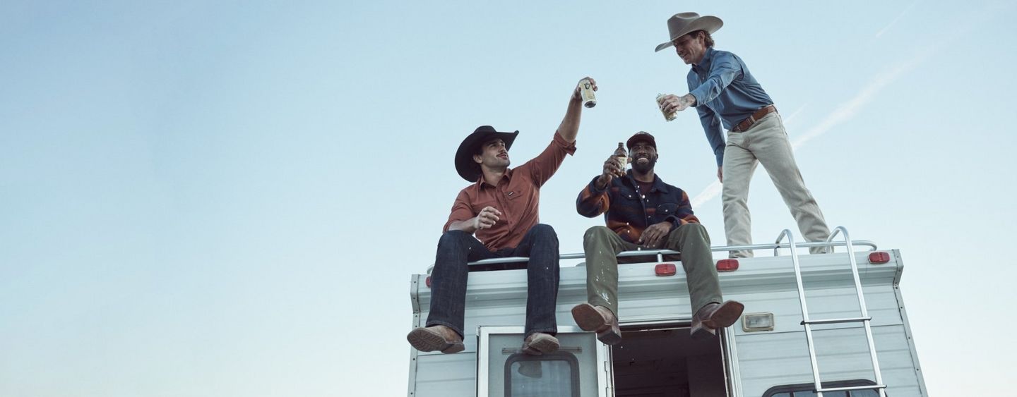 Guy wearing Wrangler Toughlite, jumping out of a cow pen.