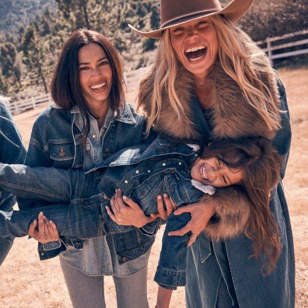 girl laughing wearing denim on denim being held up by 2 women