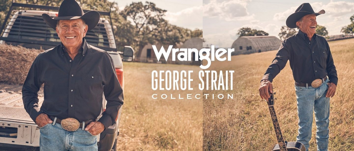 George Strait standing in a field with his guitar.