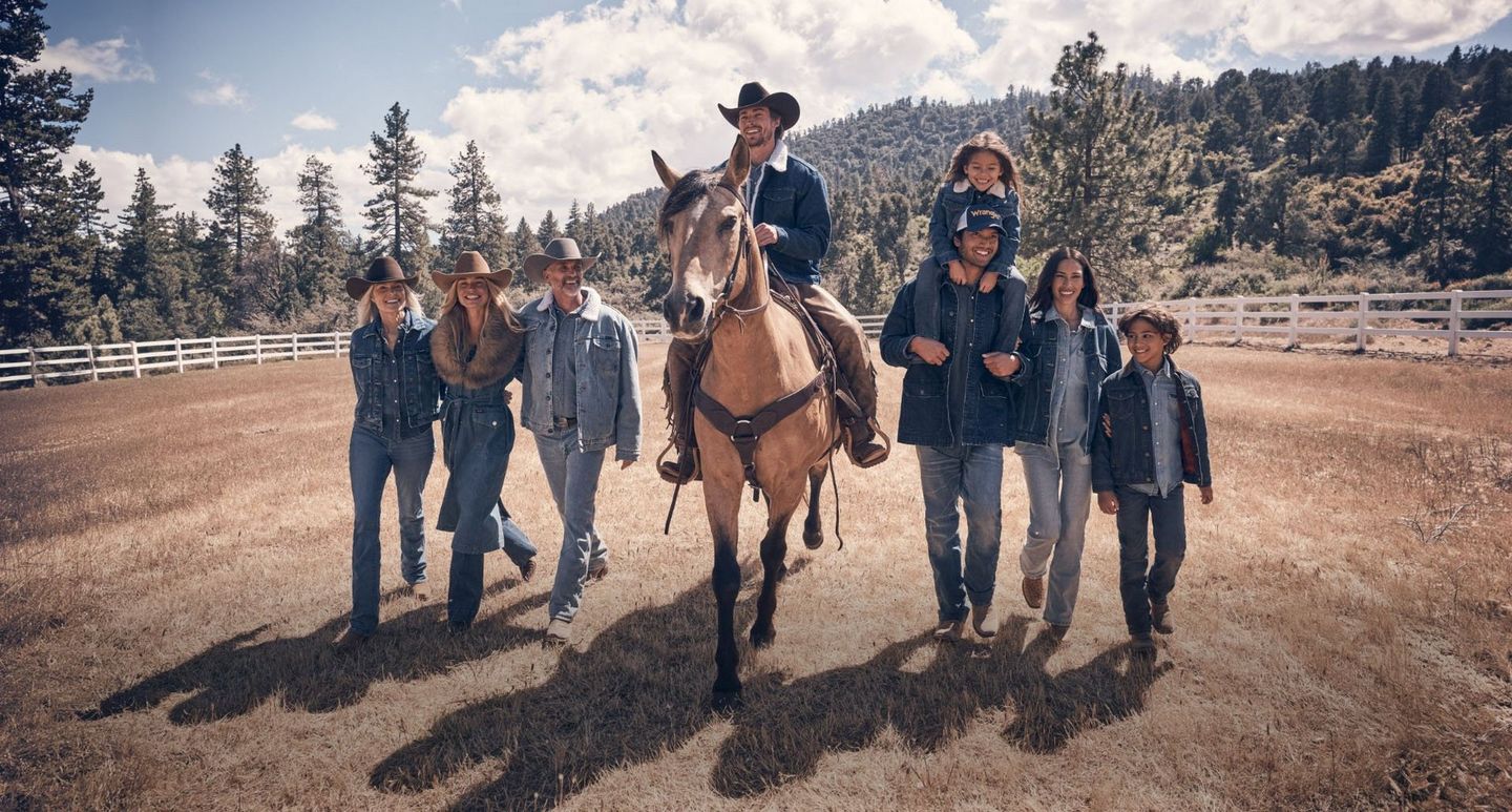 Guys and girls wearing fall clothes, gathered round a vintage truck in the woods. Shop Fall