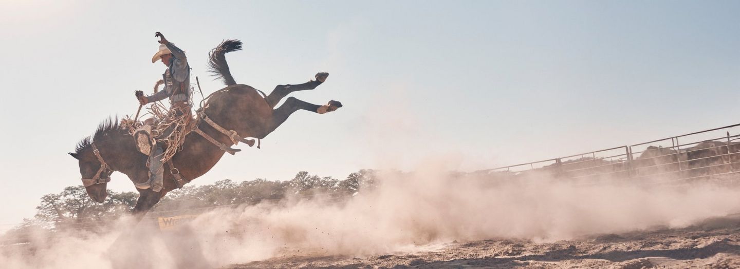 Wrangler athlete Cooper Lane riding a bucking bronco.
