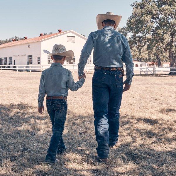 father and son walking away from camera wearing matching outfits