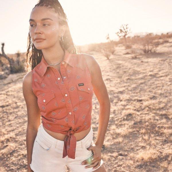 woman in a red shirt looking off to the side during sunset.