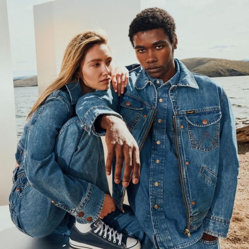 Guy and girl in studio, posing with premium denim on