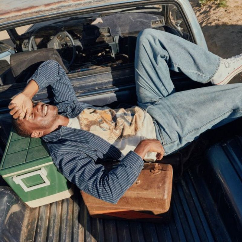 A guy laying in the back of a truck - tailgate essentials