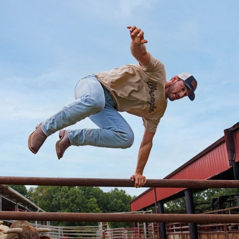A guy wearing Toughlite denim, jumping over a wall