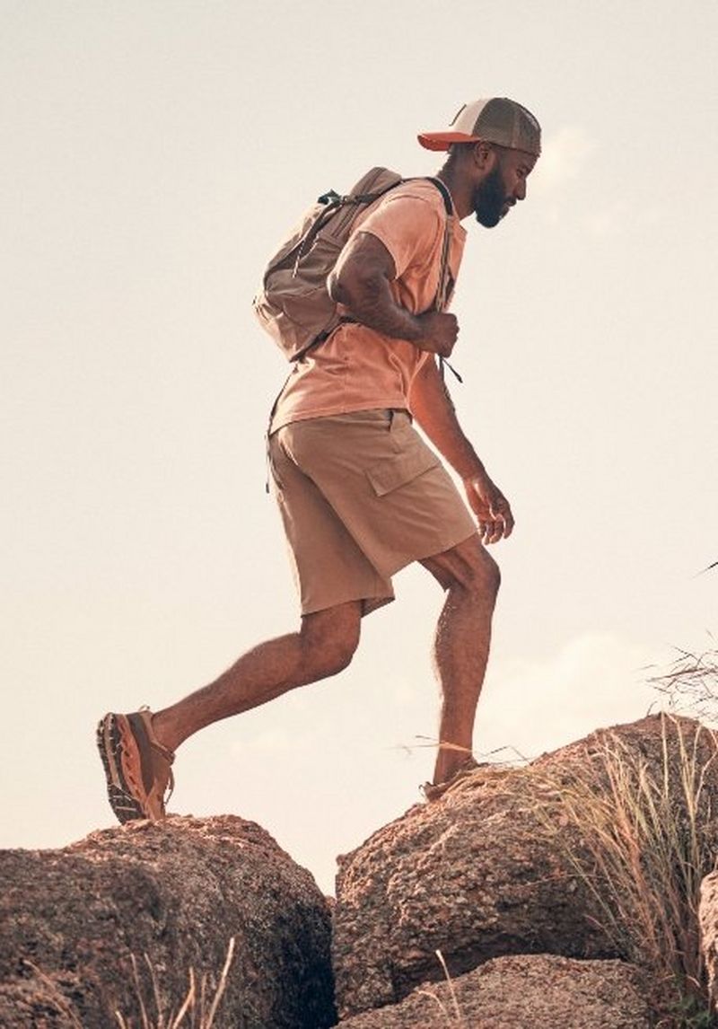 Guy hiking across massive boulders - Shop ATG