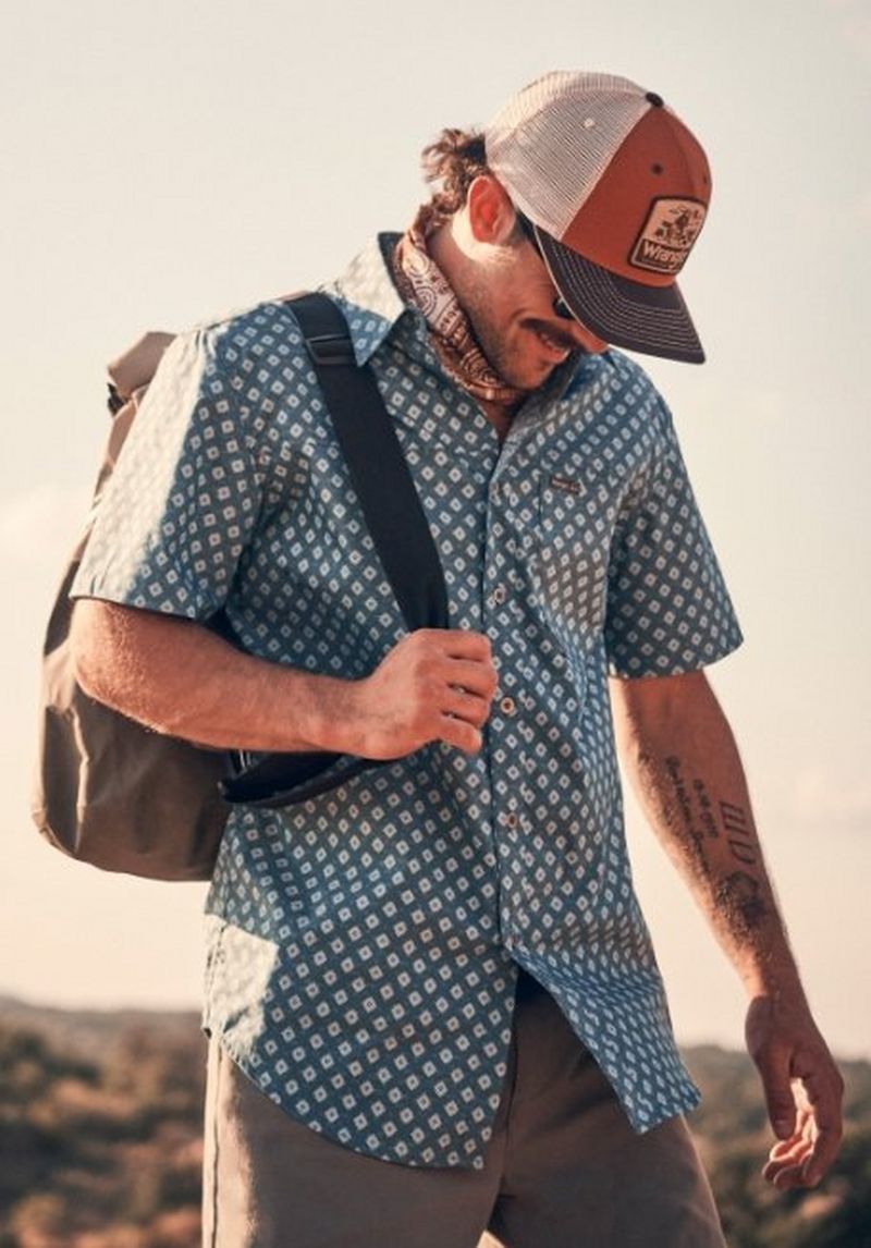 Guy wearing a button up shirt with a hat on - Shop Shirts