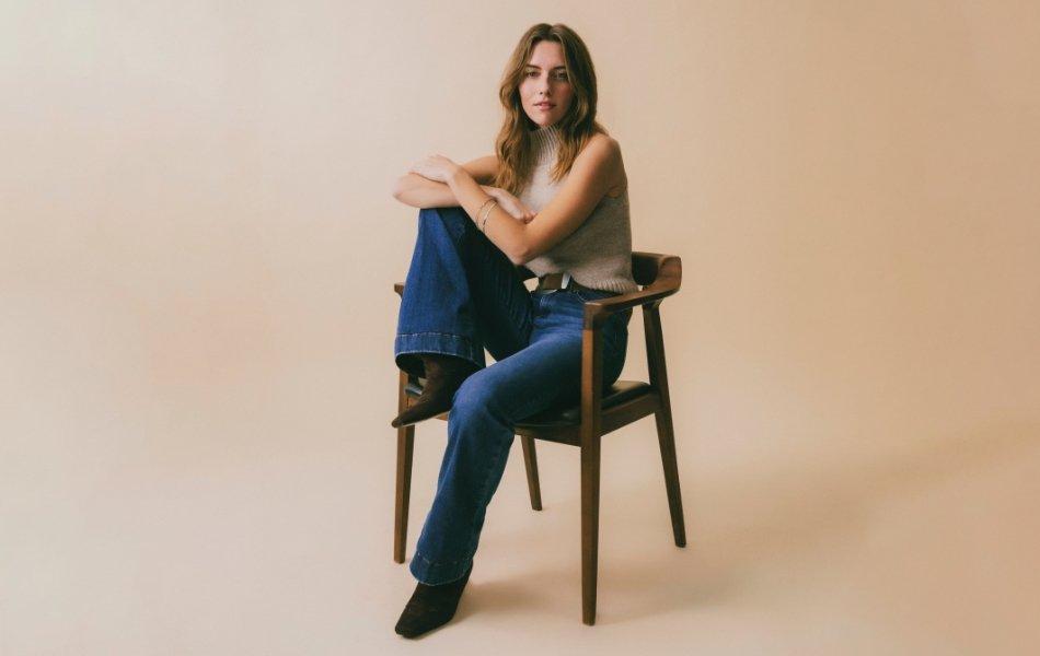 A woman sitting wearing Wrangler Bespoke jeans.