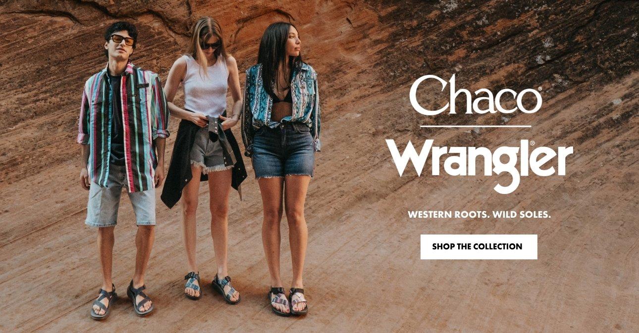 3 people standing on a monolith out was wearing Chaco and Wrangler