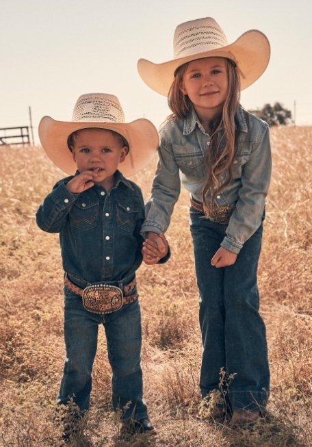 a boy and a girl holding hands and looking in the camera