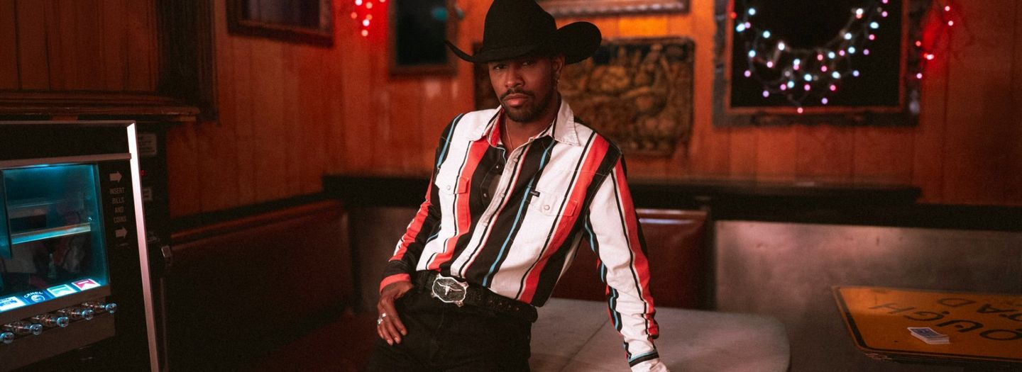 Cool guy in a cowboy hat leaned against the bar looking down - Shop Brushpopper