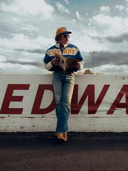 Man on a race track wearing the Wrangler X Cherry bomber jacket
