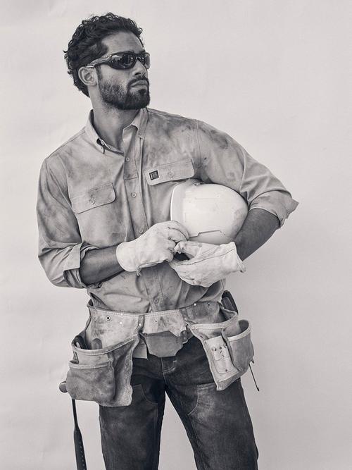 Black and White Photo of a man holding a hard hat wearing Wrangler men's workwear