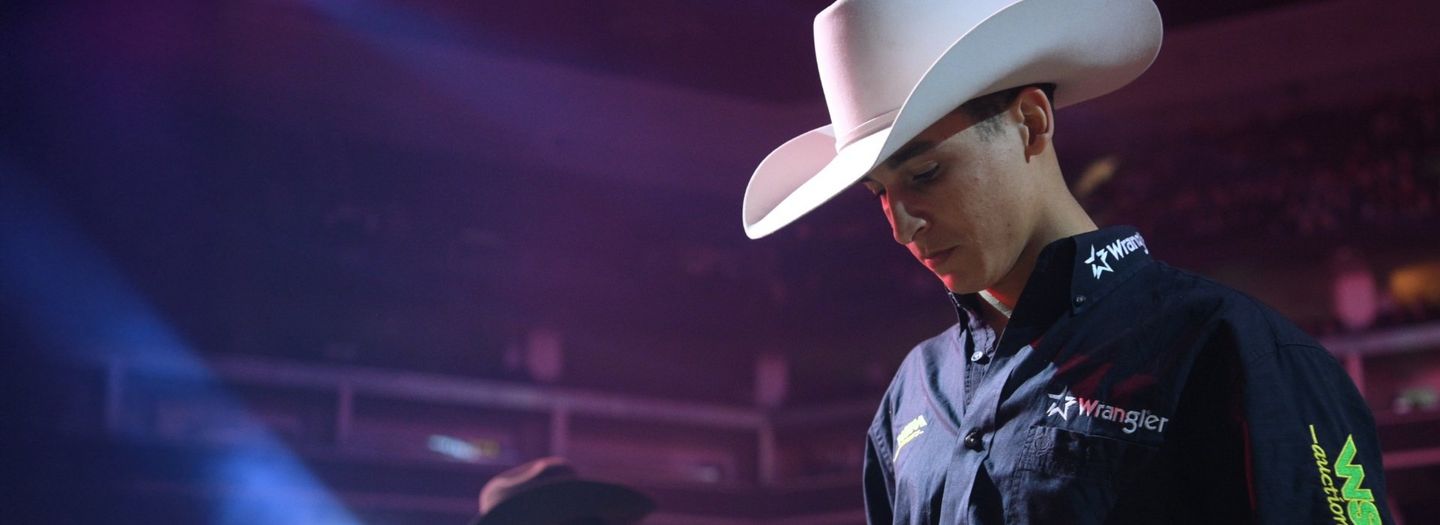 Dalton Kasel at the rodeo, in a dimly lit arena