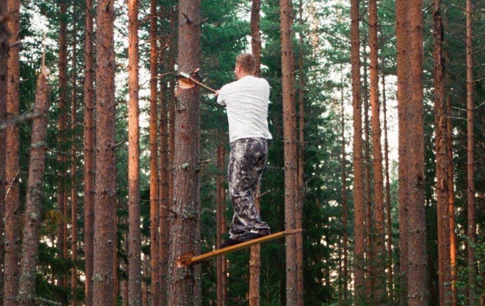 A man in the middle of the forest, standing on an axe, felling a tree - Wrangler x ROA