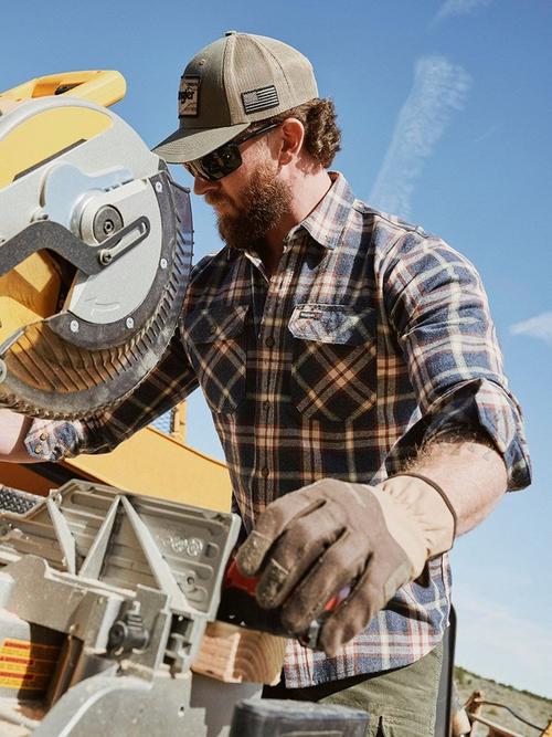 Photo of a man in a hard hat wearing a Wrangler workwear shirt